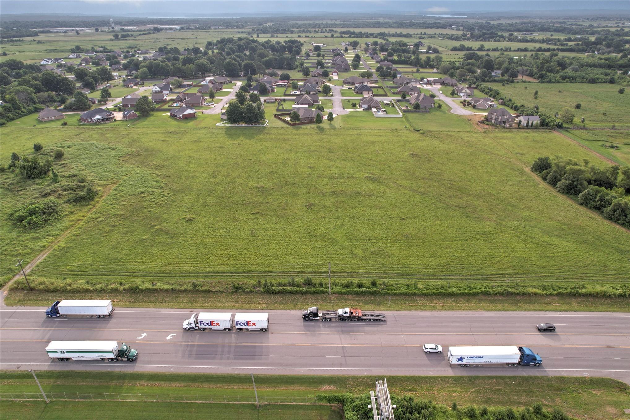 Image 3: Expansive green field with established residential
