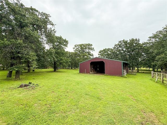 Image 2: Expansive green pasture featuring a red metal barn