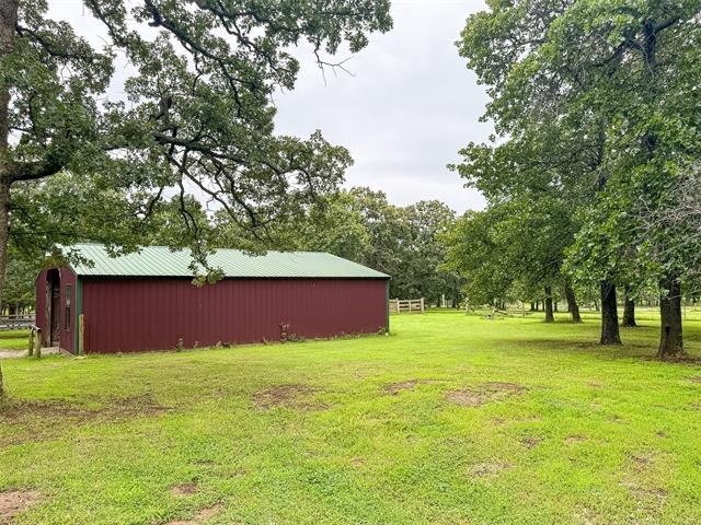Image 3: Red barn structure featuring a green metal roof an