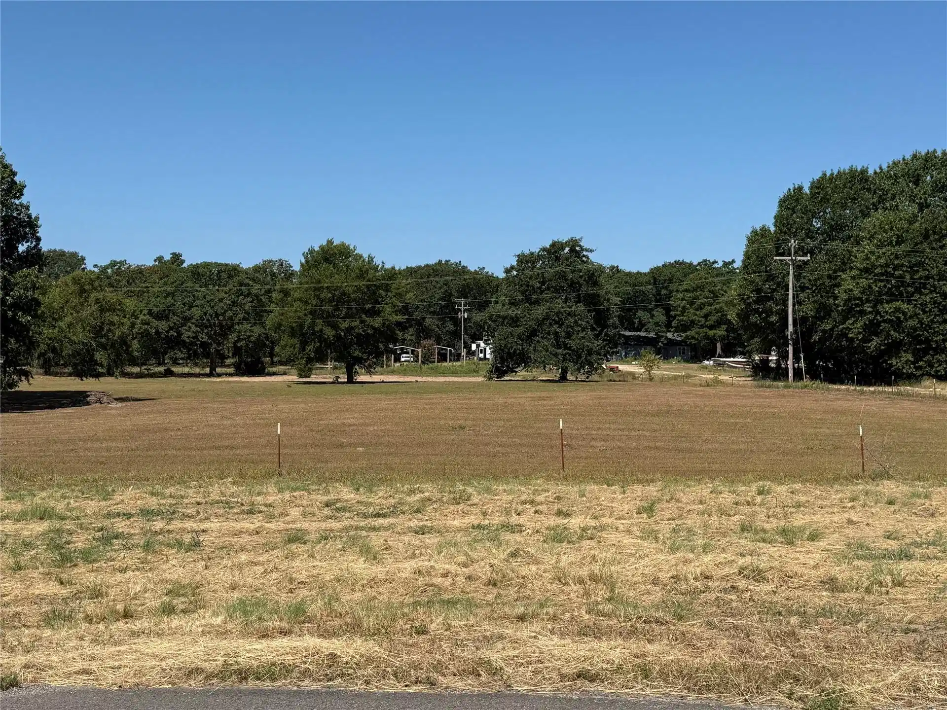 Image 1: Expansive lot with distant treeline