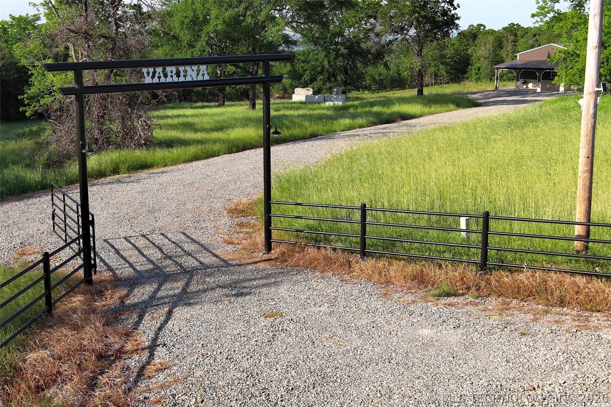 Image 2: Gravel driveway entrance featuring a black metal g