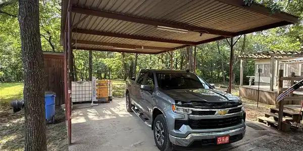 Image 3: Covered carport structure with a corrugated metal