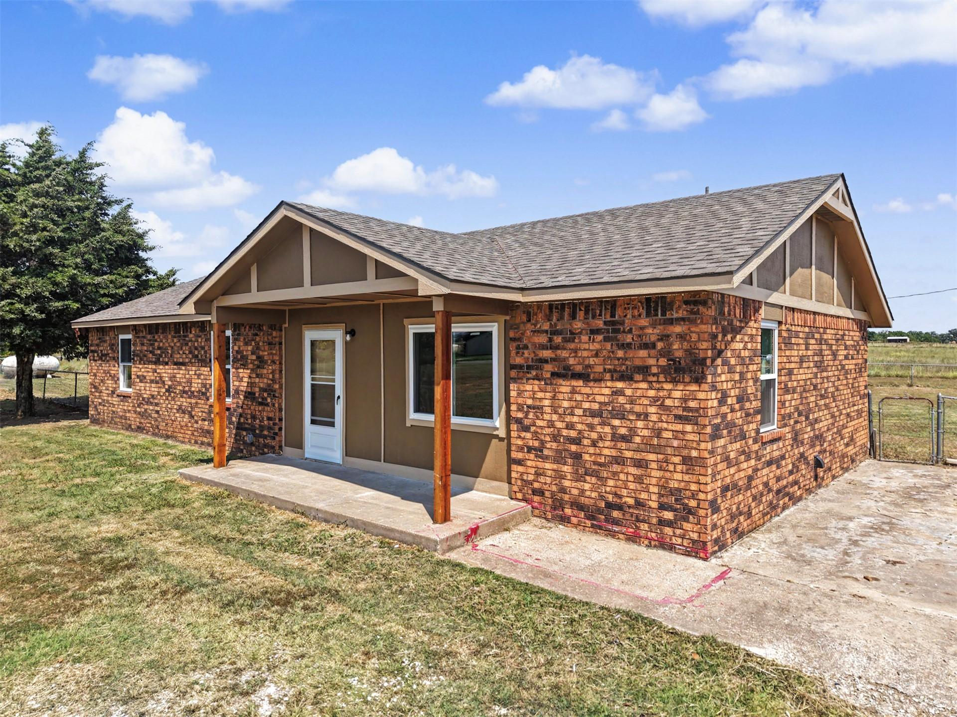 Image 4: Brick and stucco exterior featuring a covered fron