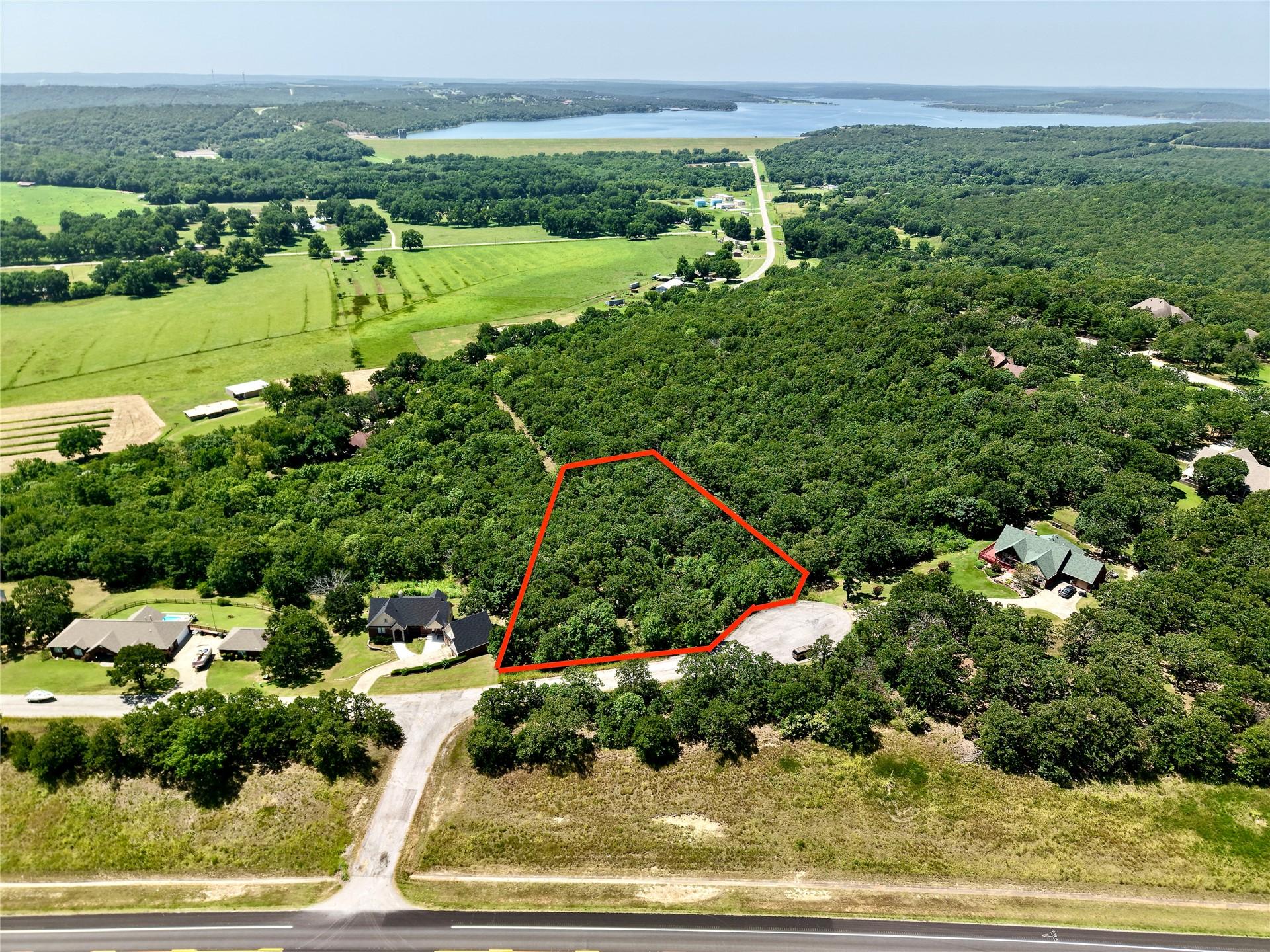 Image 1: Aerial view of a heavily wooded lot, outlined in r