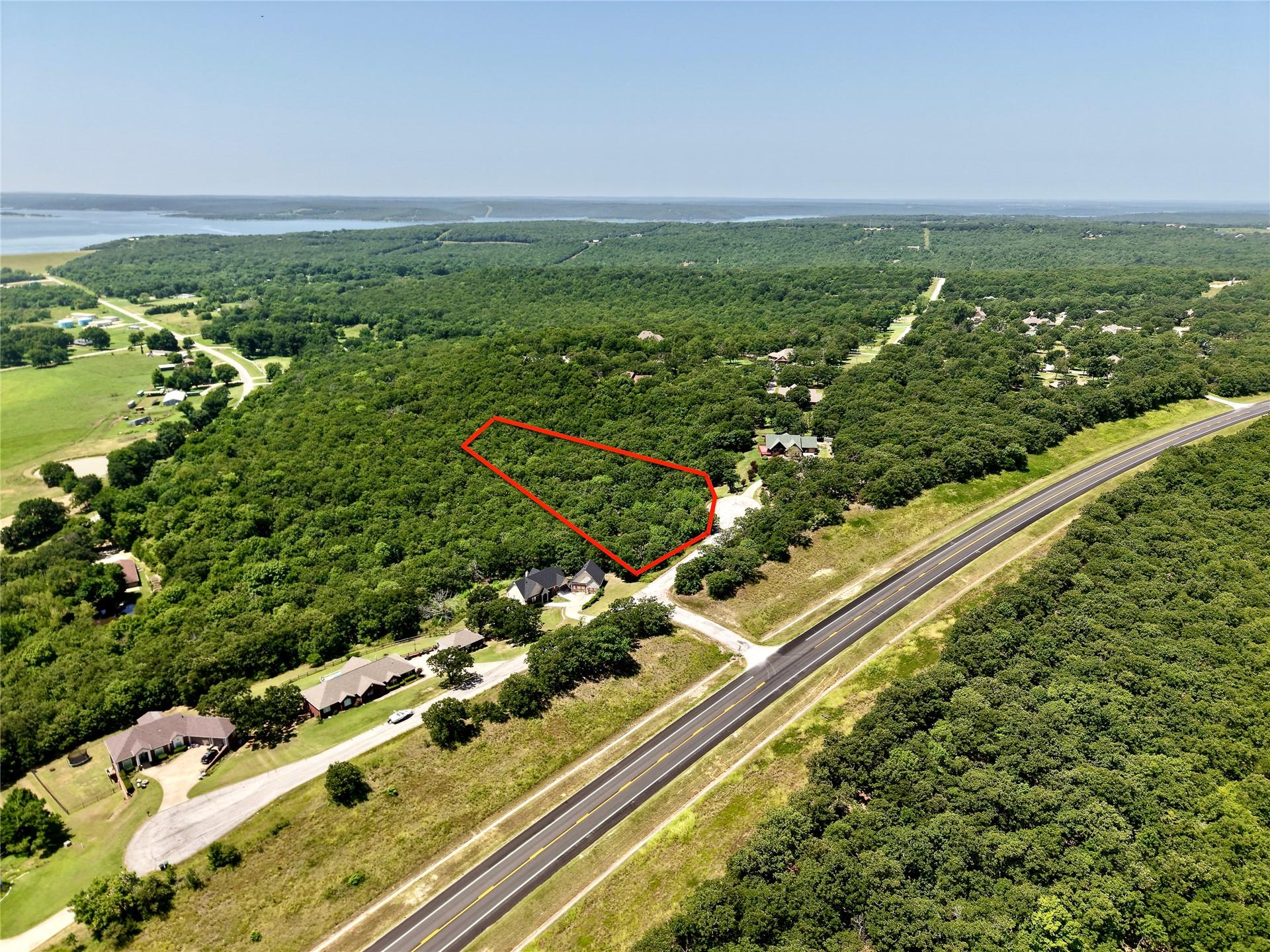 Image 2: Wooded acreage with highway frontage and a water b