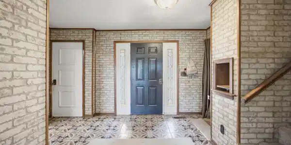 Image 4: Entryway featuring a dark paneled door with decora