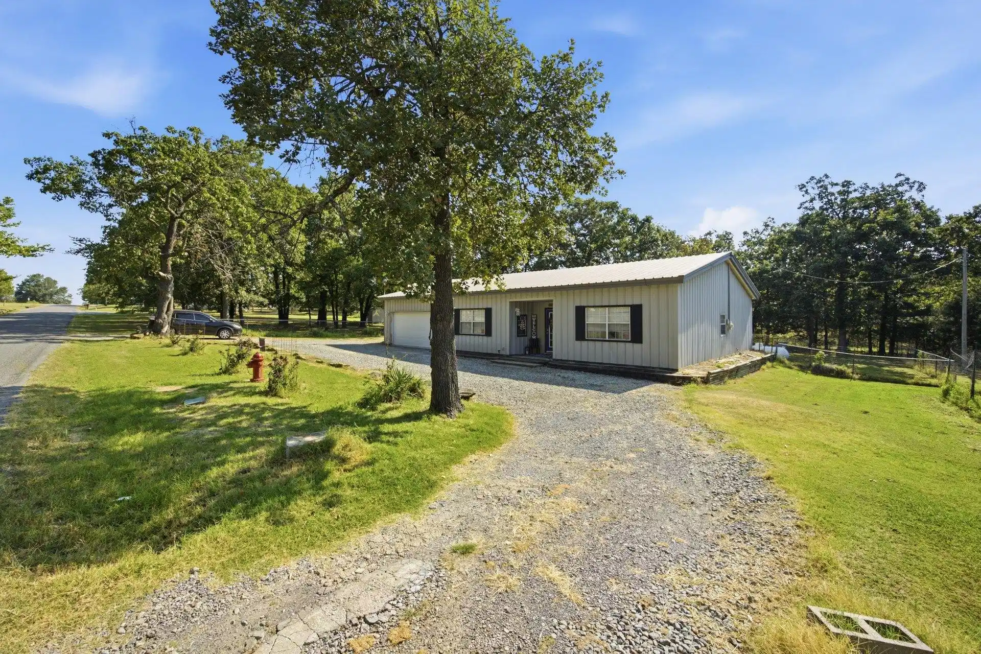 Image 1: Metal-sided residence with an attached garage, a g