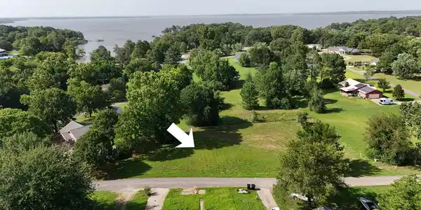 Image 3: Expansive grassy lot bordered by mature trees, off