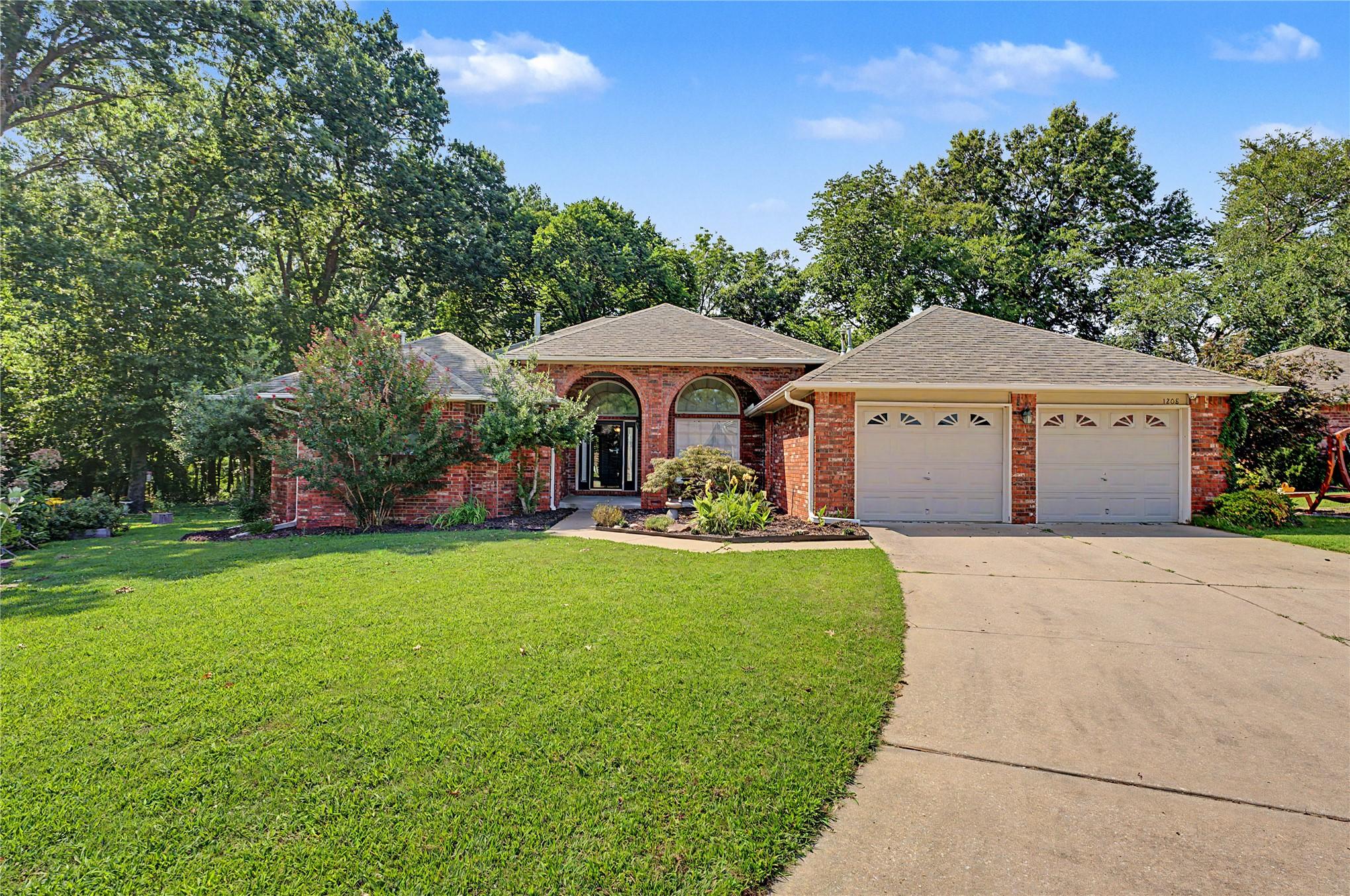 Image 2: Brick facade residence with a two-car garage, arch