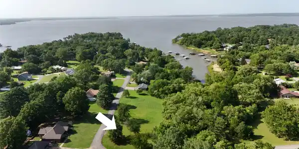 Image 4: Expansive lot featuring mature trees and a clear,