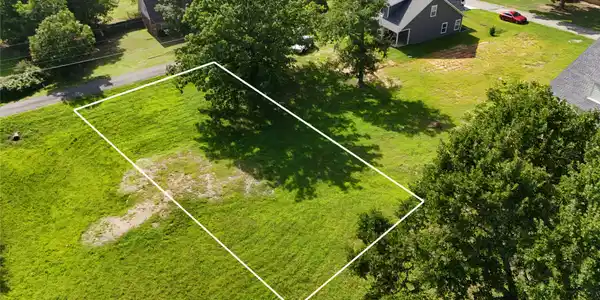 Image 2: Expansive grassy lot bordered by mature trees