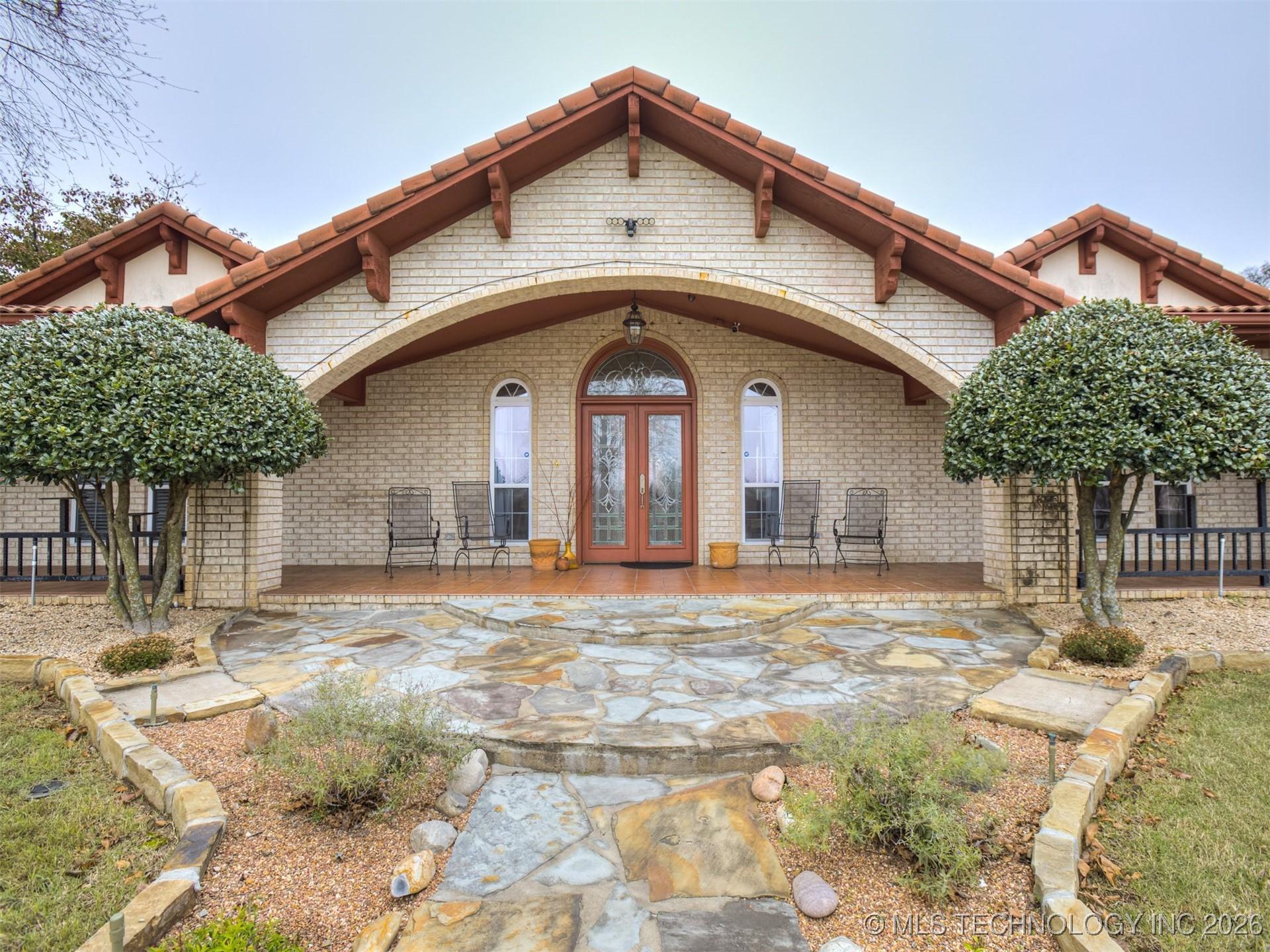 Image 2: Entry with wrap around porch, tile roof