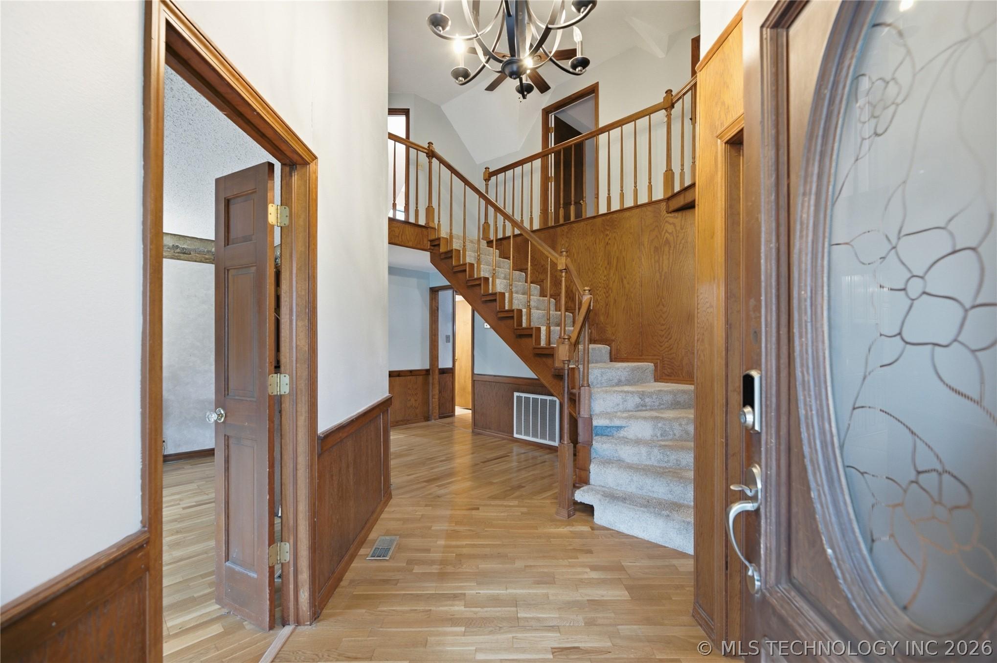 Image 2: Grand foyer with a sweeping staircase, rich woodwo