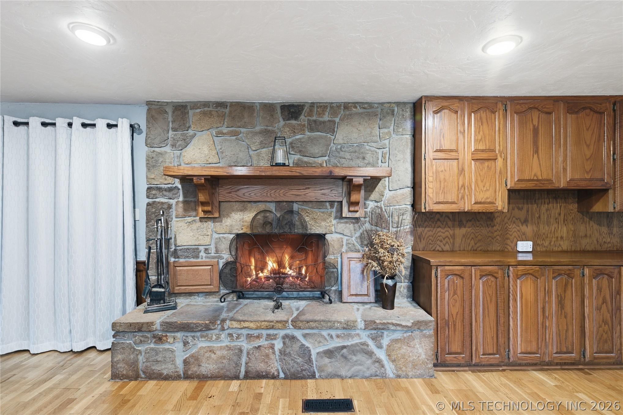 Image 4: Floor-to-ceiling stone fireplace anchors the impre