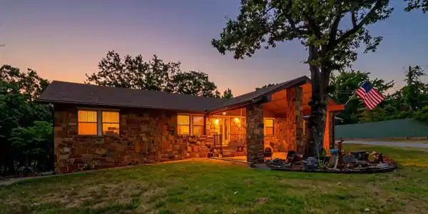 Image 3: Stone veneer exterior with a covered porch and a m