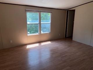 Image 4: Wood-finish flooring, neutral-toned walls, and dou