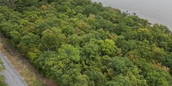 Image 3: Wooded property with water frontage and a paved ro
