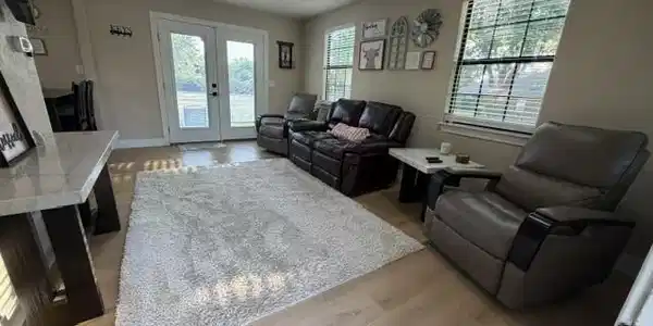 Image 2: Spacious living area featuring light wood-finish f