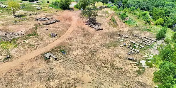 Image 3: Expansive cleared land with multiple building mate