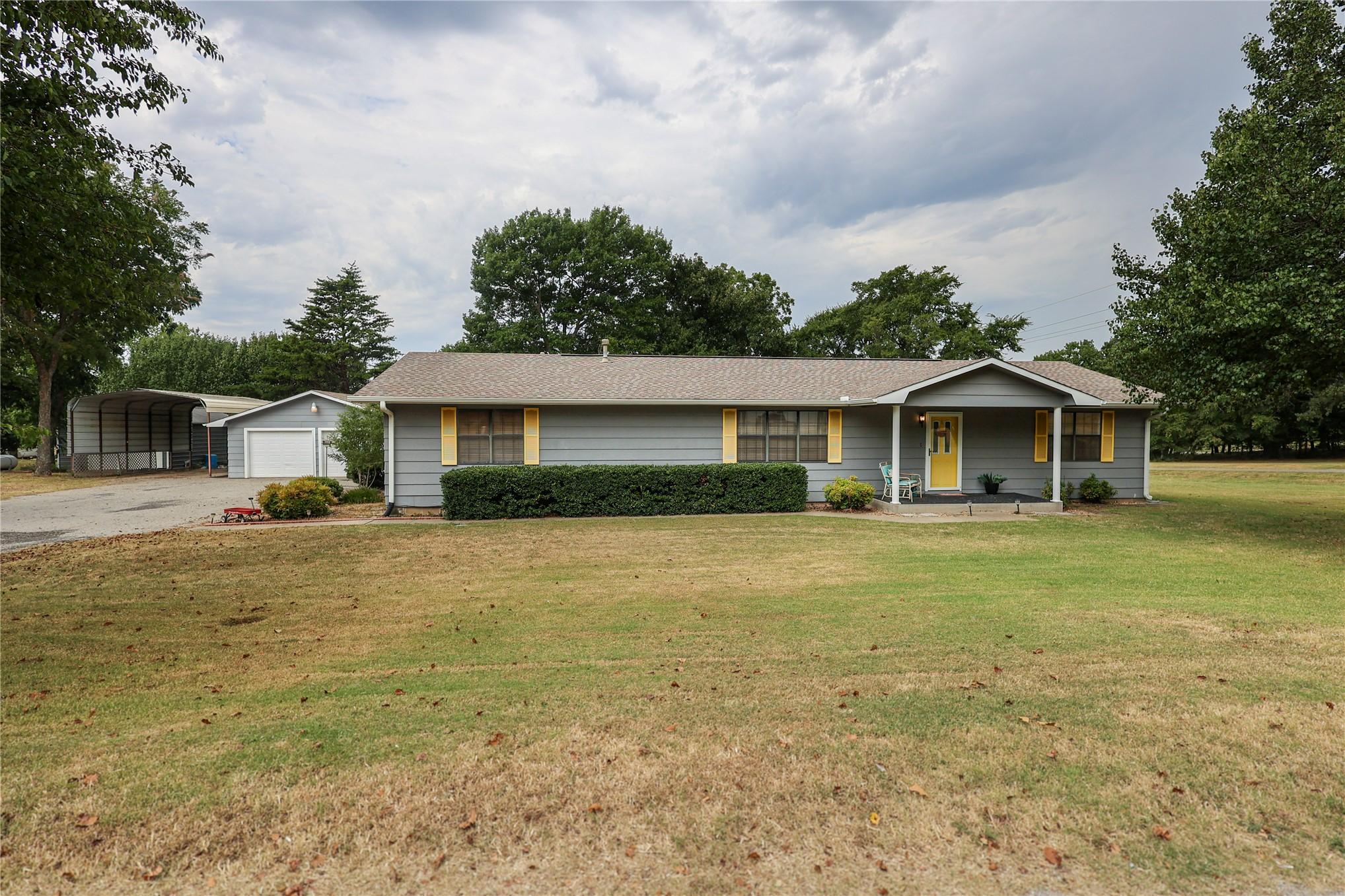 Image 1: Ranch-style residence featuring gray siding and a