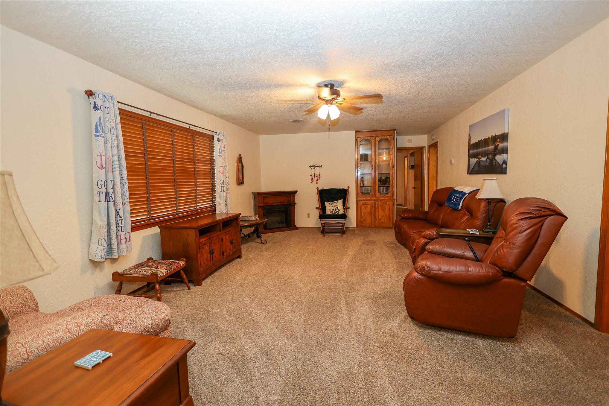 Image 2: Spacious living area featuring neutral carpeting,