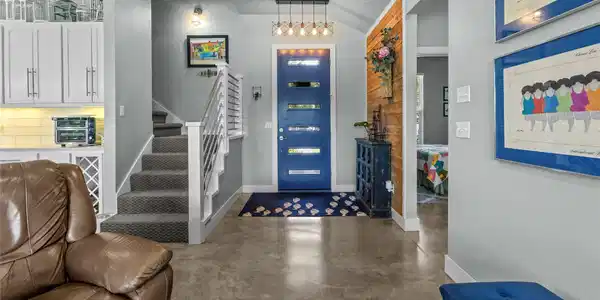 Image 4: Modern entryway featuring a blue front door with h