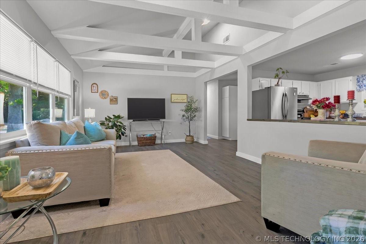 Image 4: Living area featuring vaulted ceilings with expose