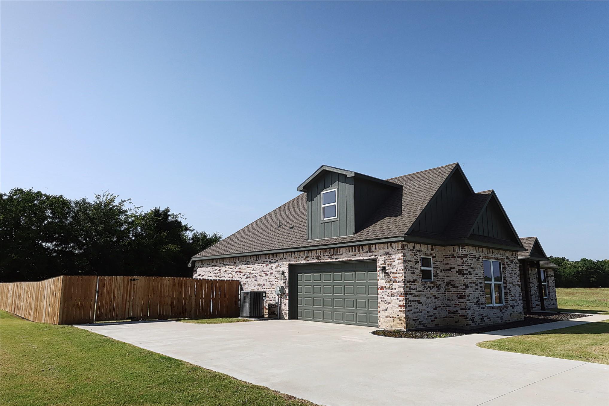 Image 2: Brick exterior with dark siding accents, attached