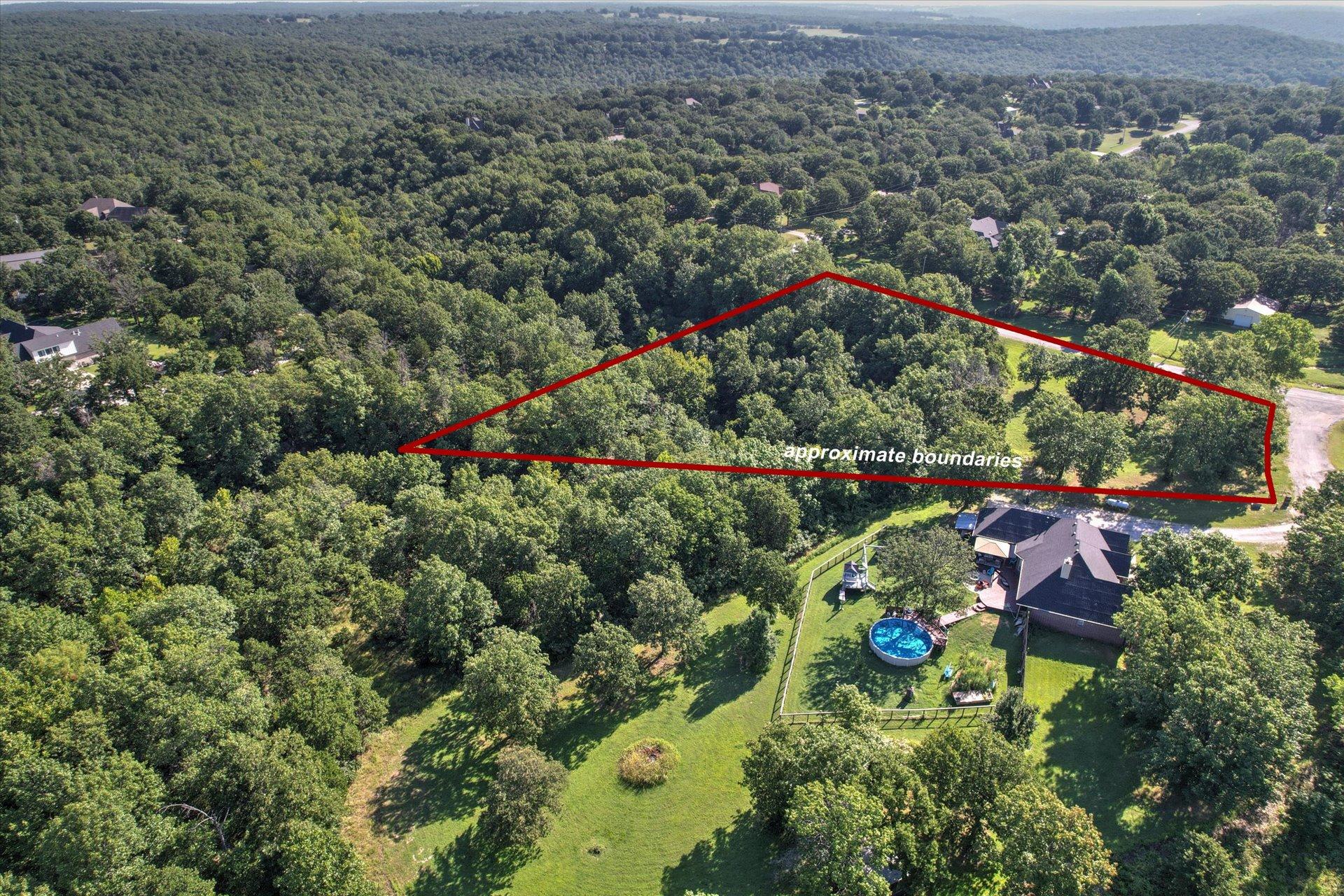 Image 1: Expansive wooded acreage with a cleared building s
