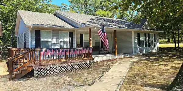 Image 2: Light blue siding exterior featuring a covered por