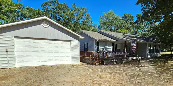Image 3: Detached garage with a paneled door, gray horizont