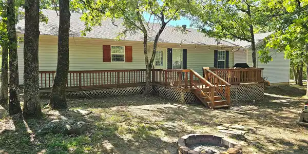 Image 4: Rear exterior featuring light-colored siding, a mu