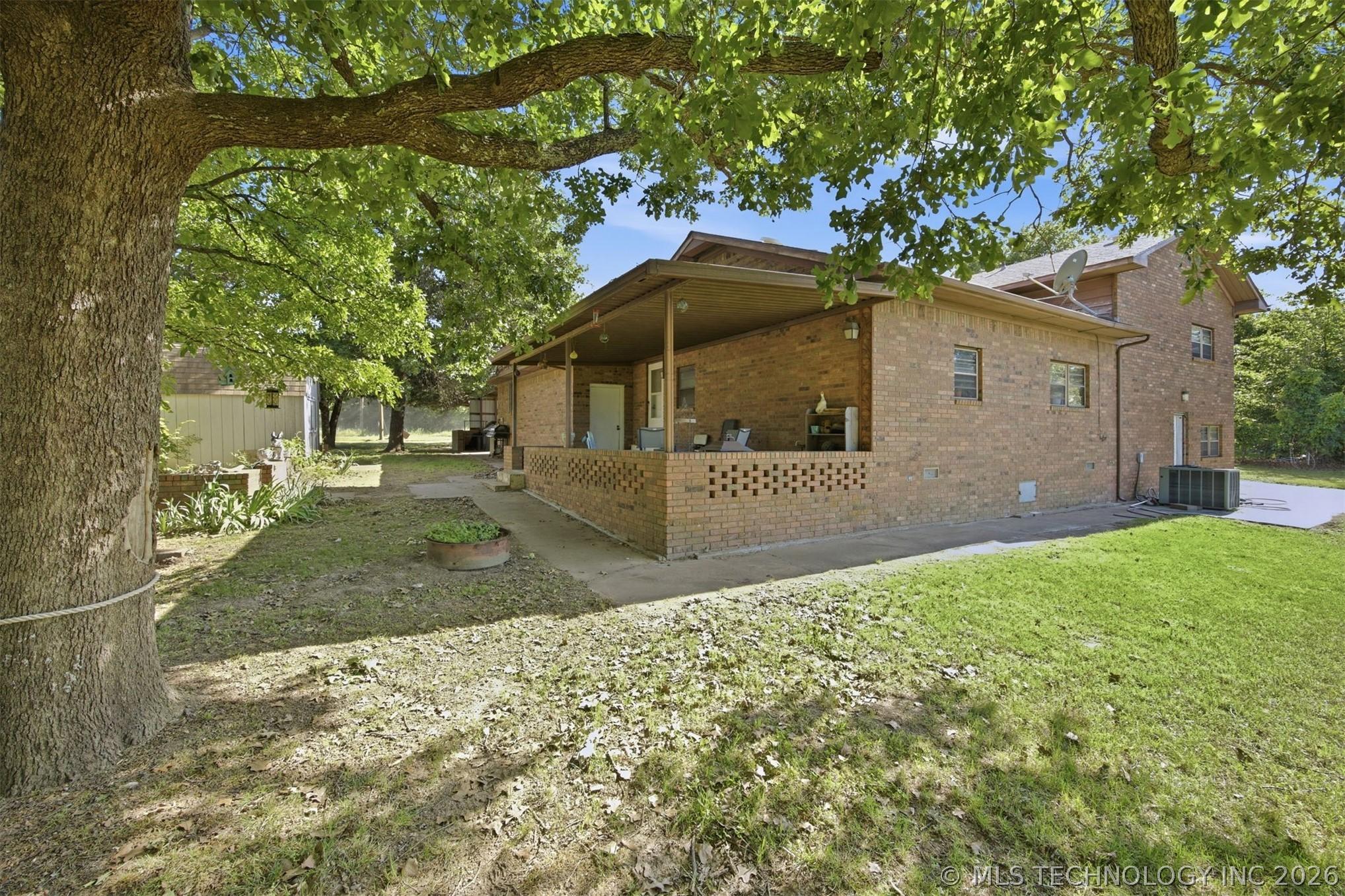 Image 2: Brick exterior featuring a covered patio, a verdan