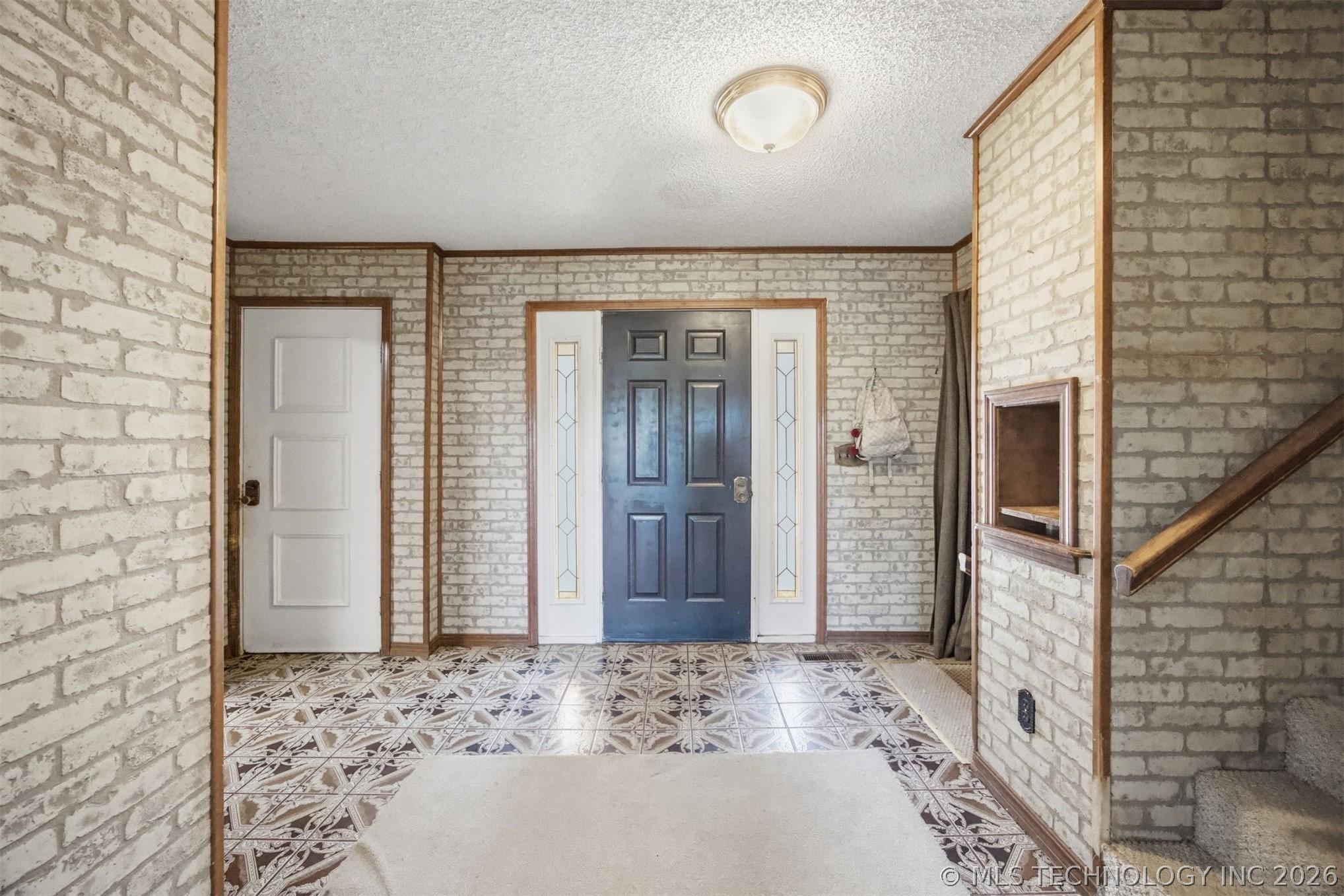Image 4: Entryway featuring a dark paneled door with decora