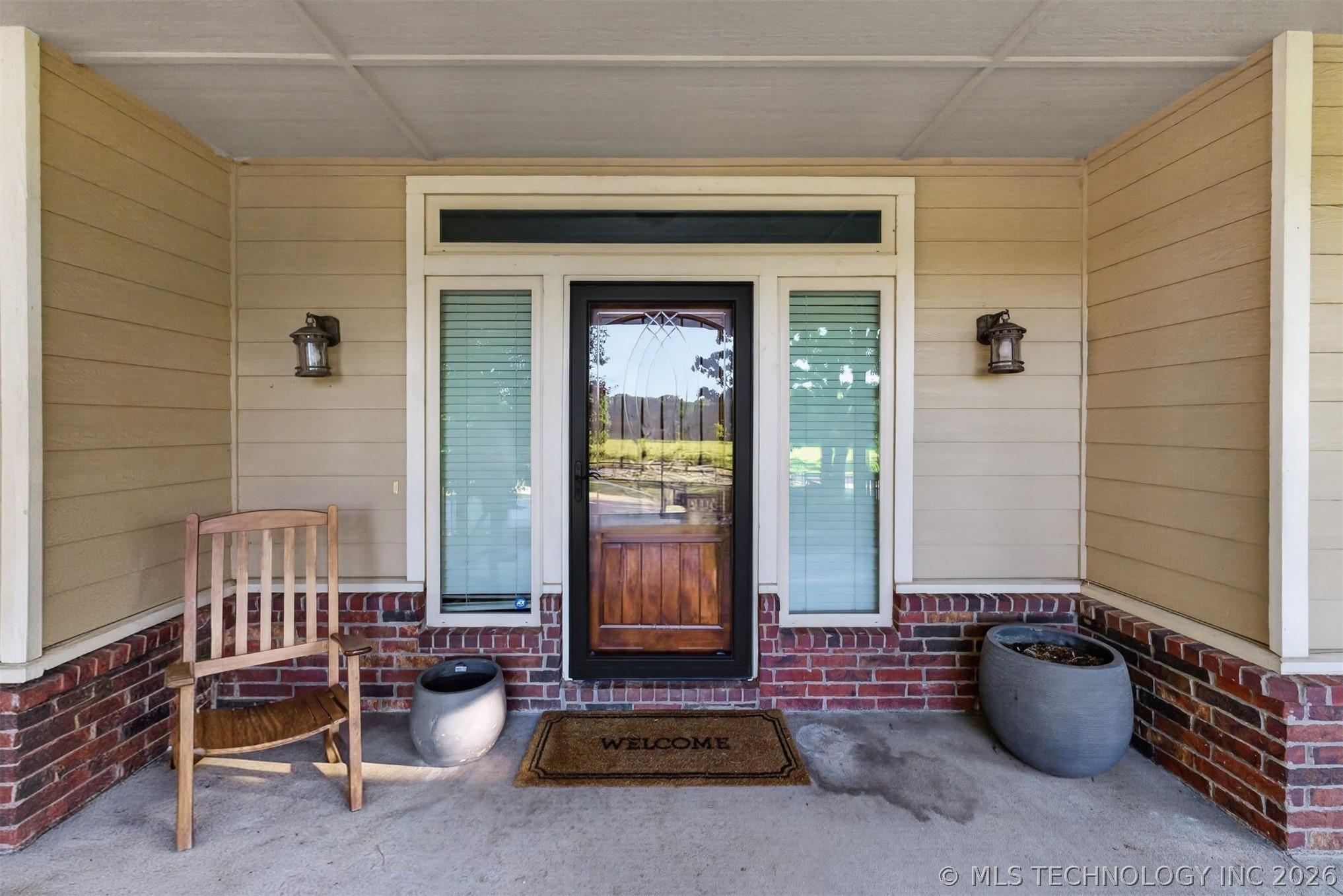 Image 3: Inviting covered porch featuring a wood-finish ent