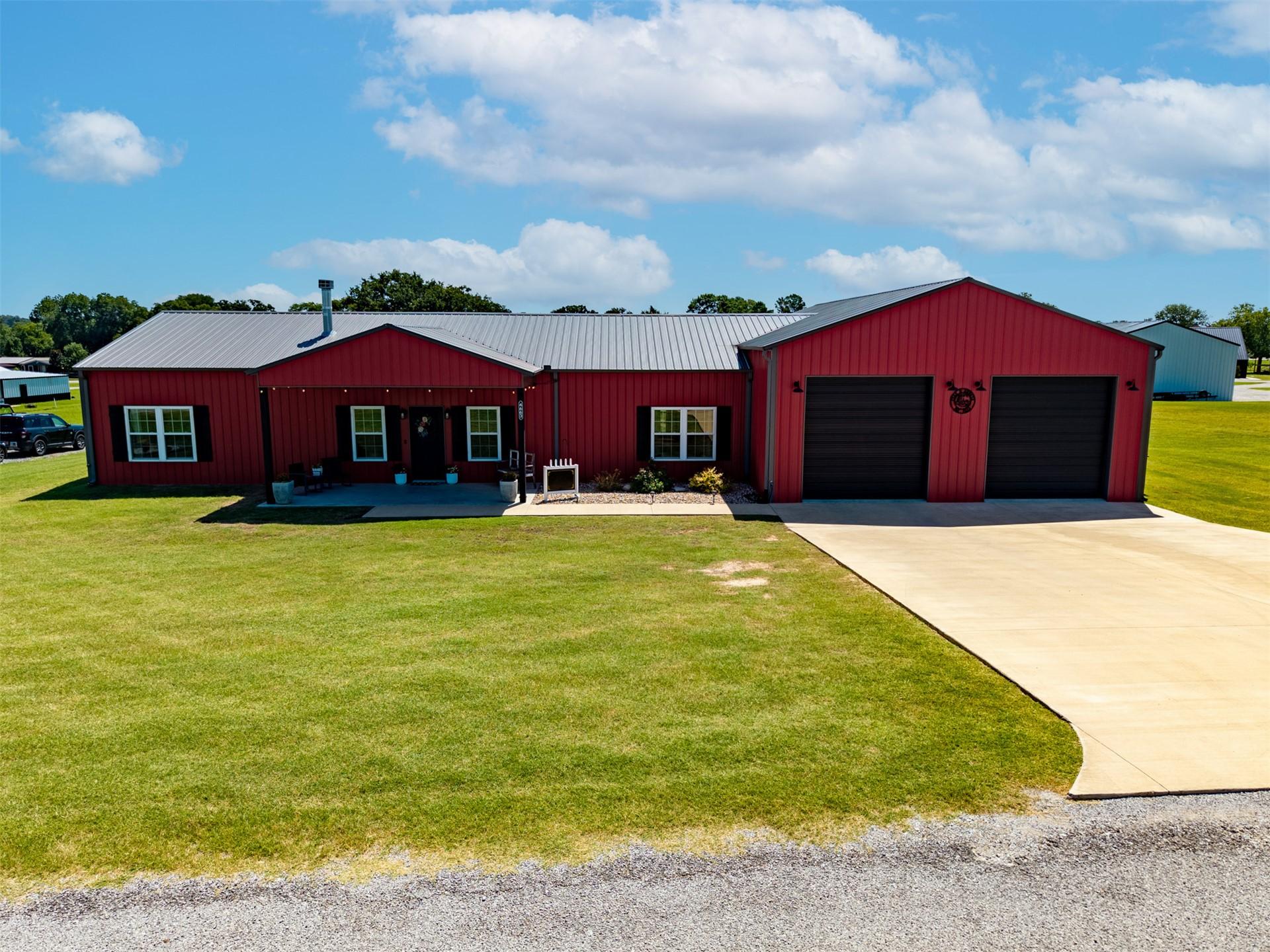 Image 1: Red-sided residence featuring a gray metal roof an