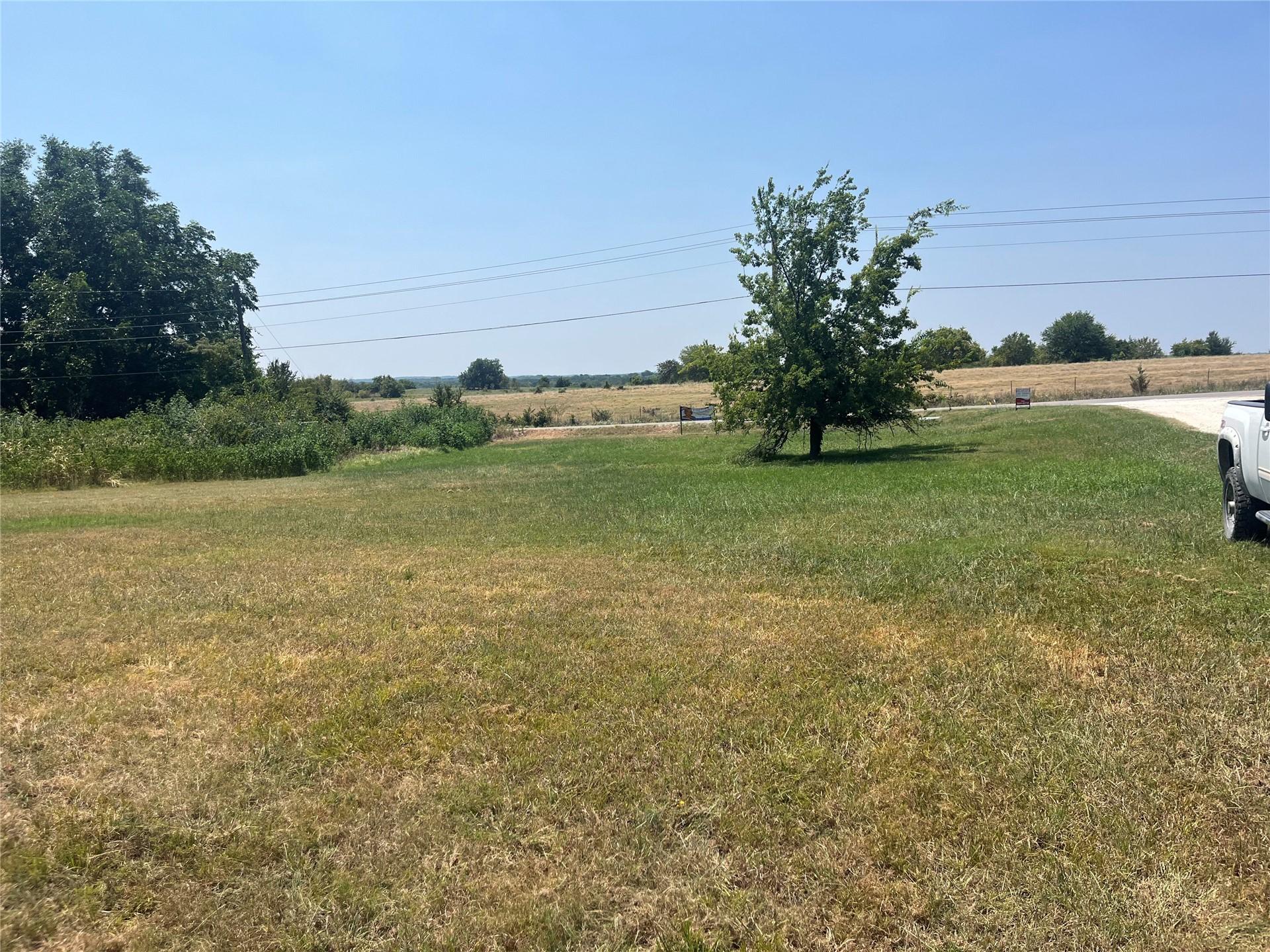 Image 2: Expansive open land featuring a mix of green and d