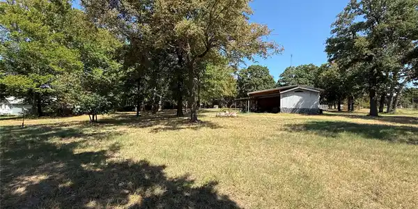Image 3: Expansive yard featuring mature trees and a detach