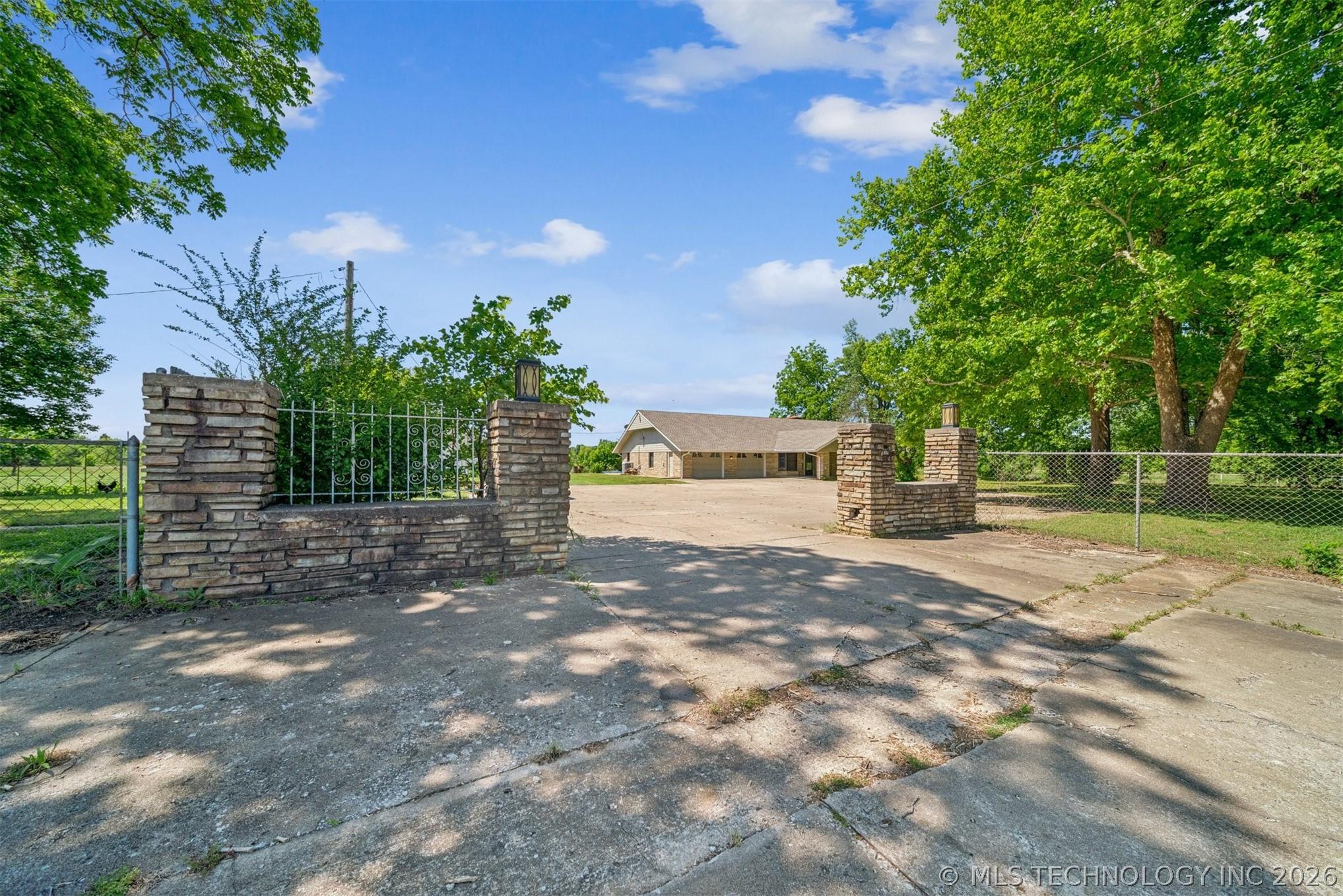 Image 3: Concrete driveway leading to a residence with a li