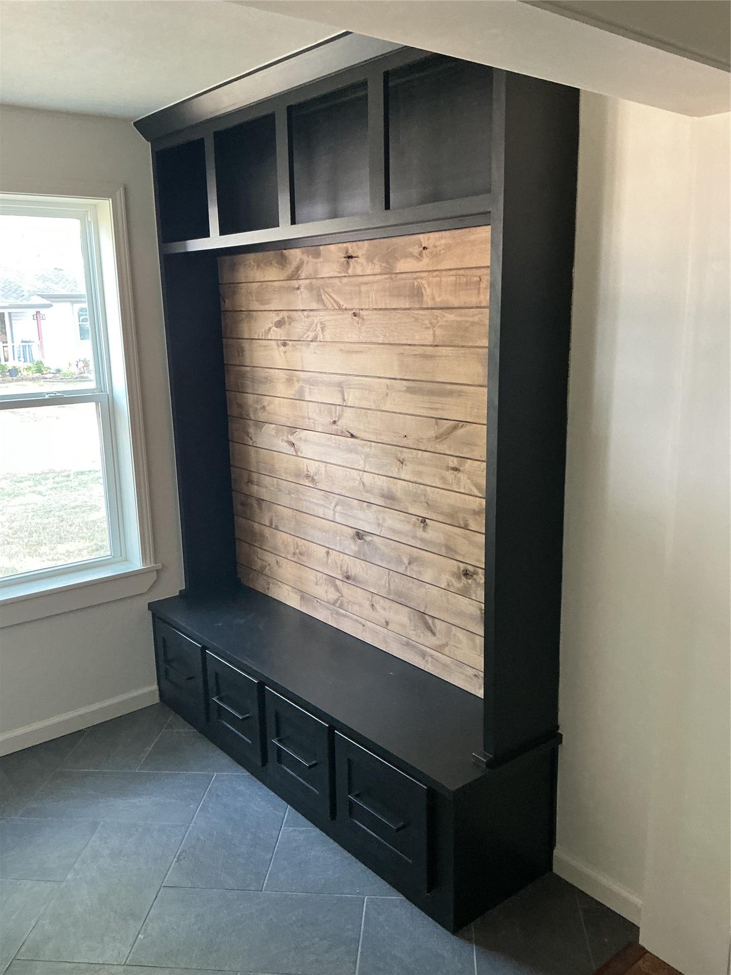 Image 4: Built-in storage unit featuring a wood-panel accen