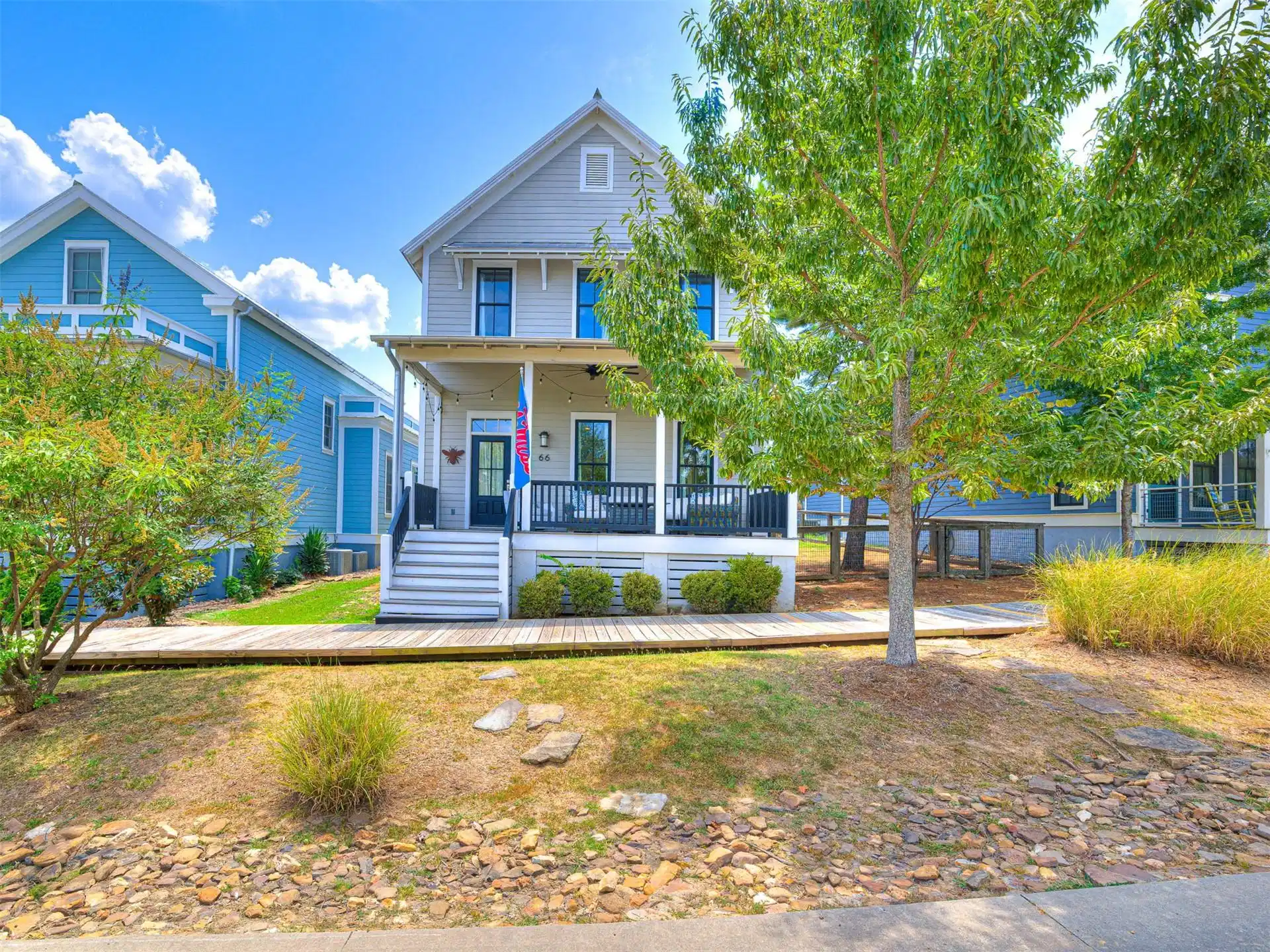 Image 1: Light-toned exterior with a covered porch, dark en