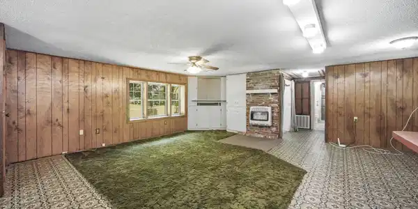 Image 3: Large open living area with windows overlooking ba