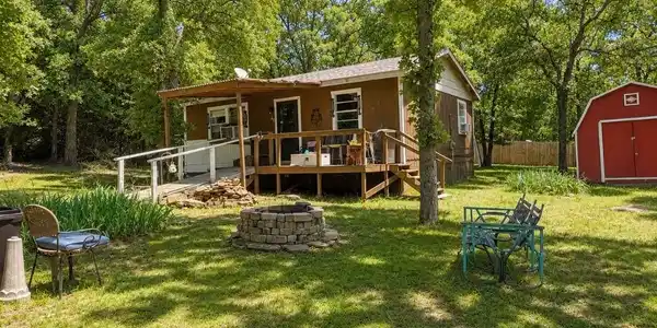 Image 2: Expansive grassy yard featuring a stone-ringed fir