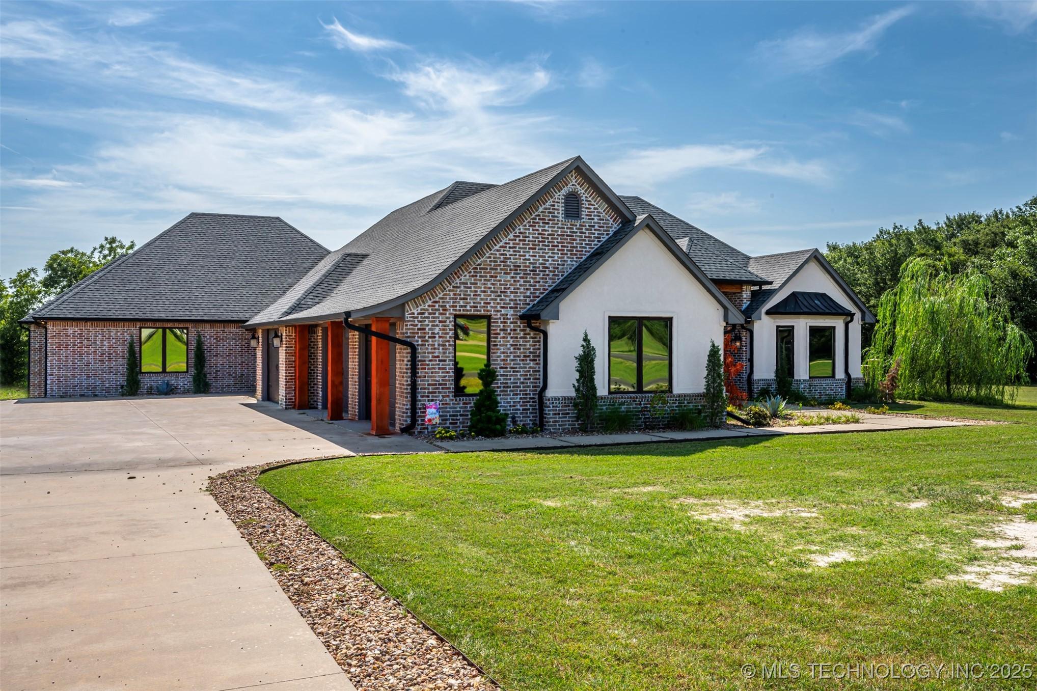 Image 1: Northwest Side- Front of House, Driveway, Garages