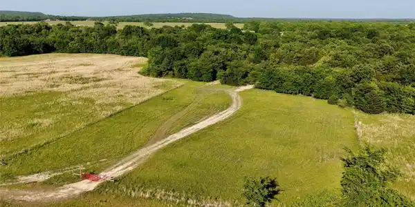 Image 4: Expansive rural acreage featuring a winding dirt r
