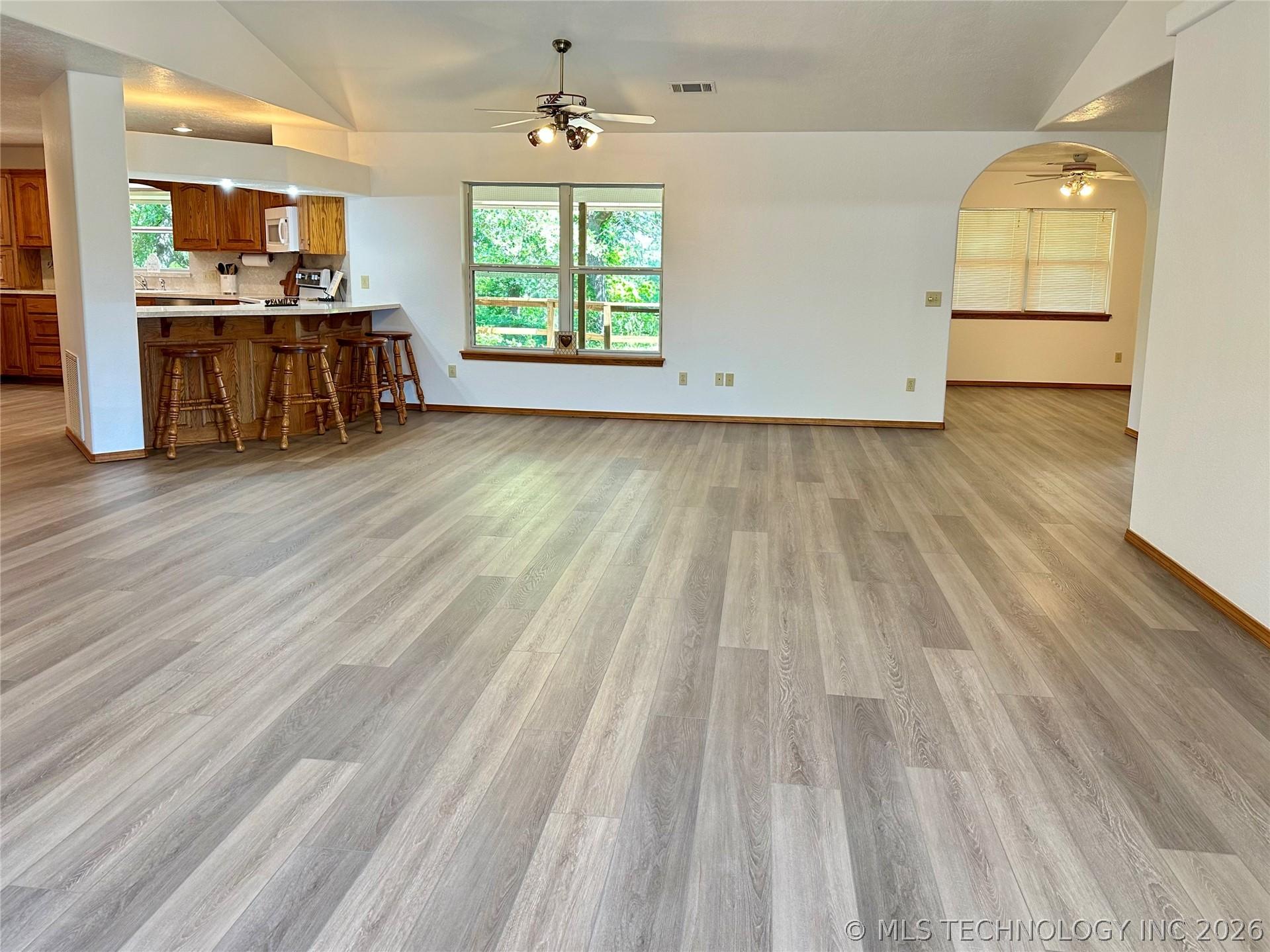 Image 3: Spacious interior featuring wood-finish flooring,