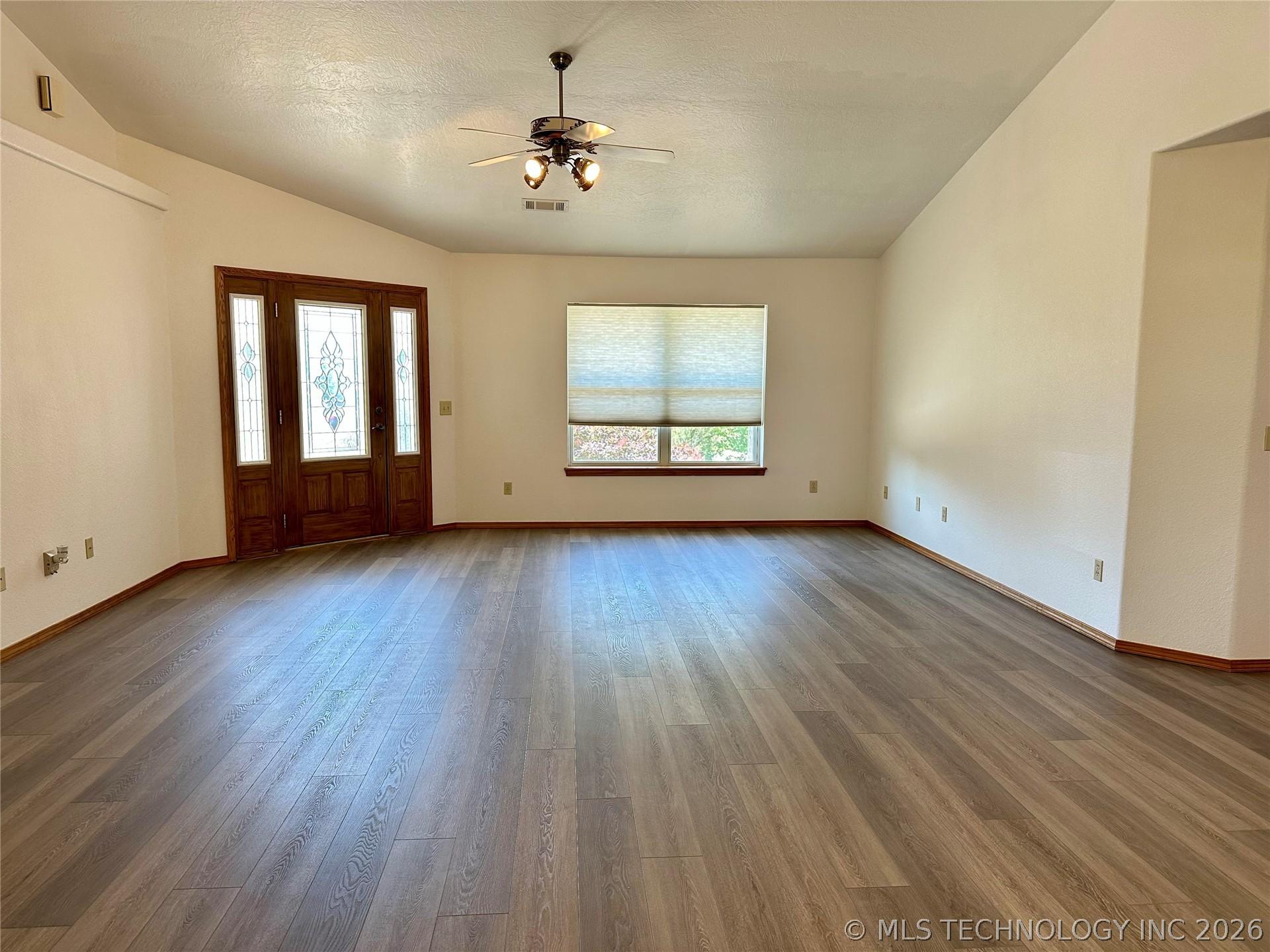 Image 4: Spacious living area featuring wood-finish floorin