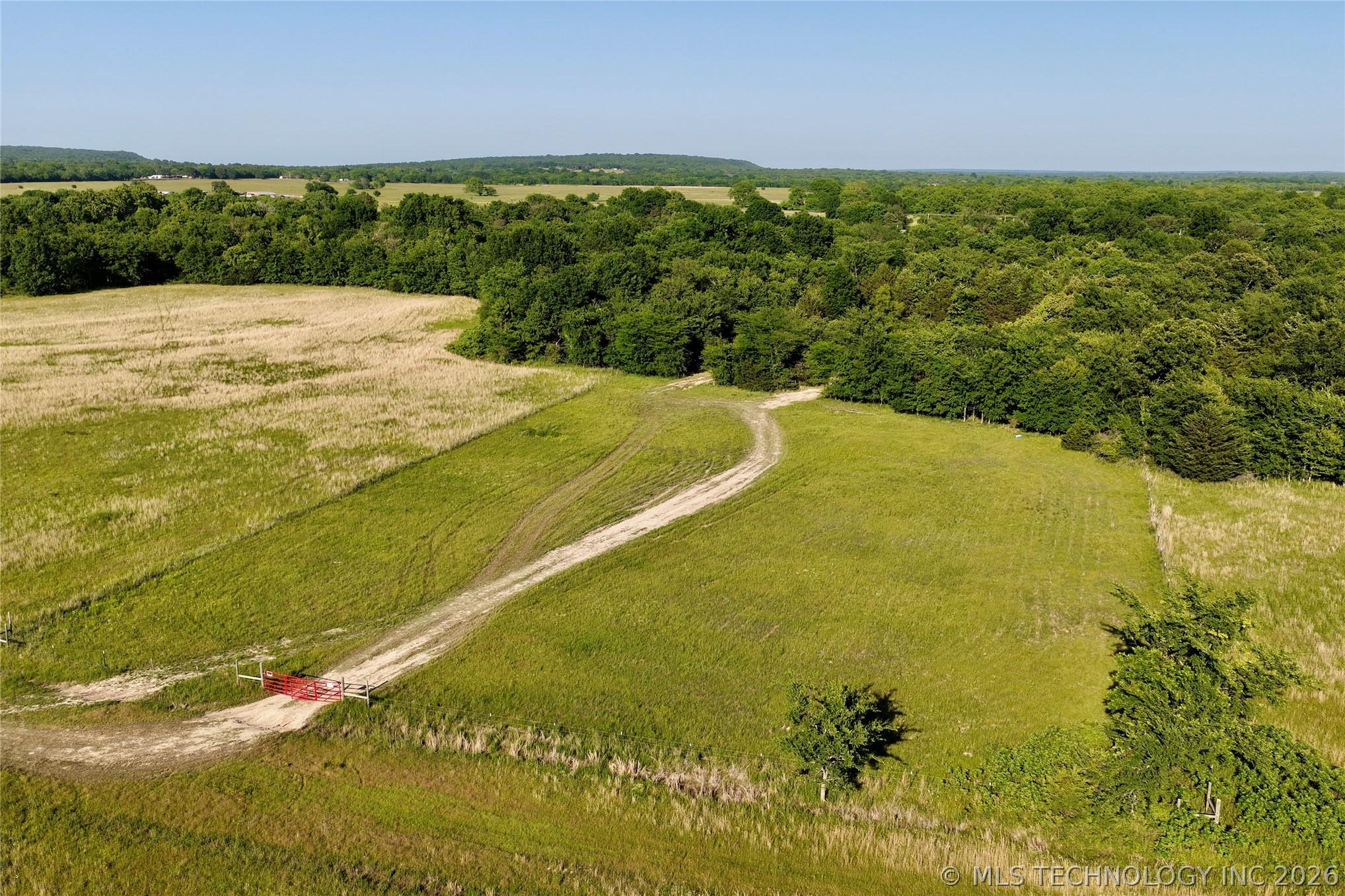 Image 4: Expansive rural acreage featuring a winding dirt r