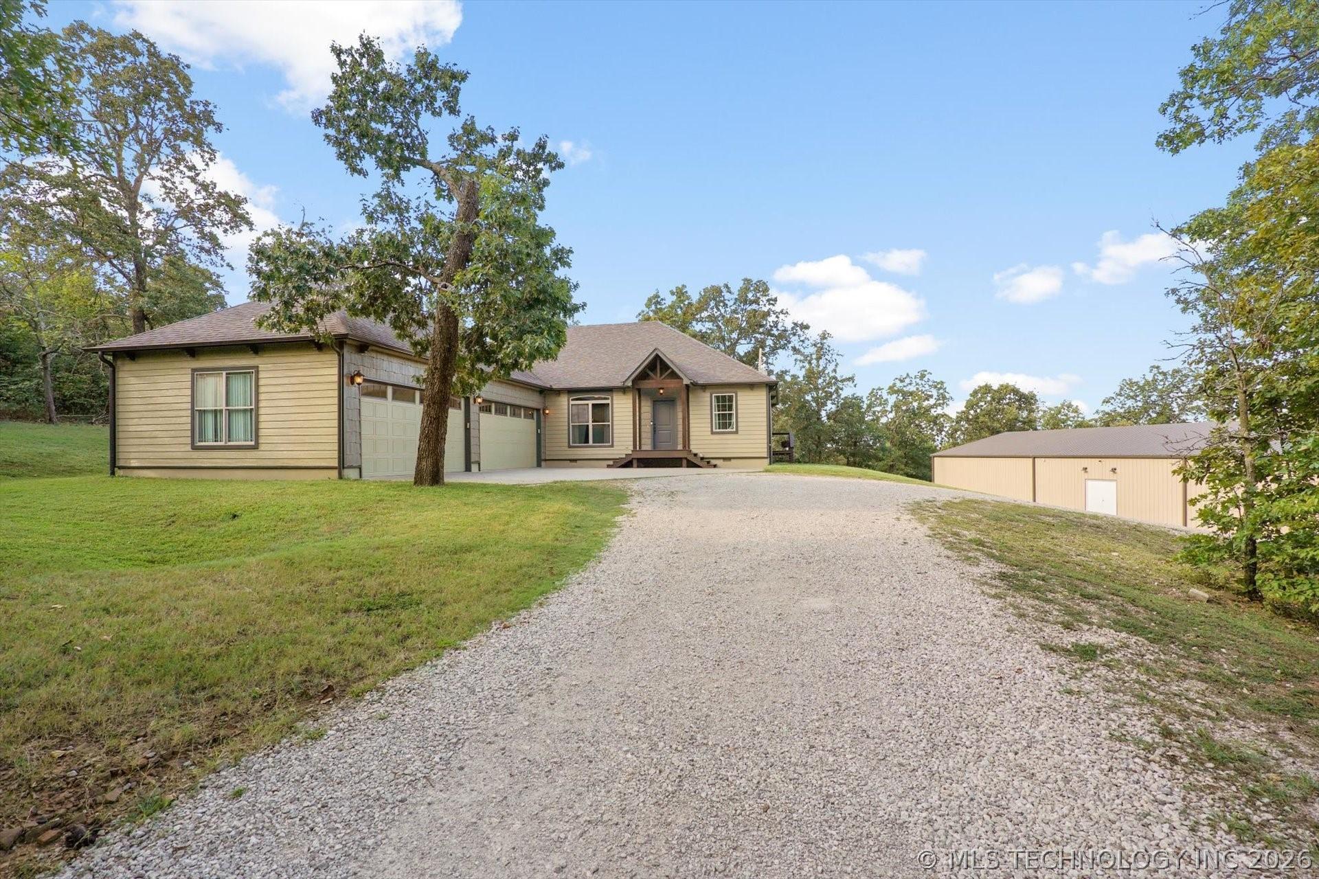 Image 2: Front view of home showcasing manicured landscapin