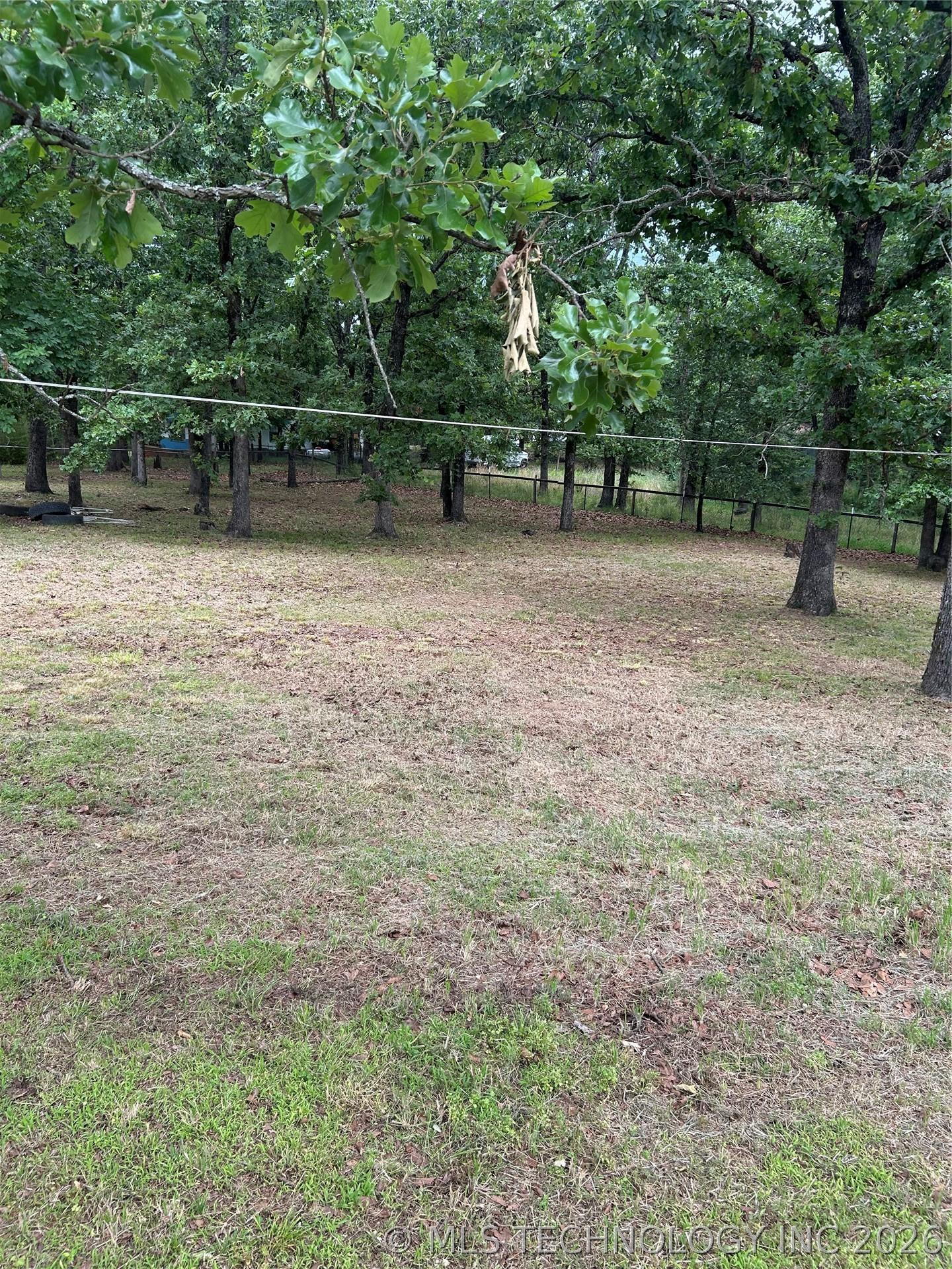 Image 3: Expansive wooded lot featuring mature trees, a par